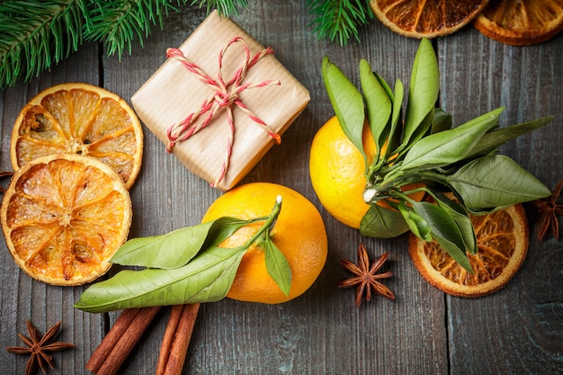 Decoración navideña con caja de regalo y mandarinas