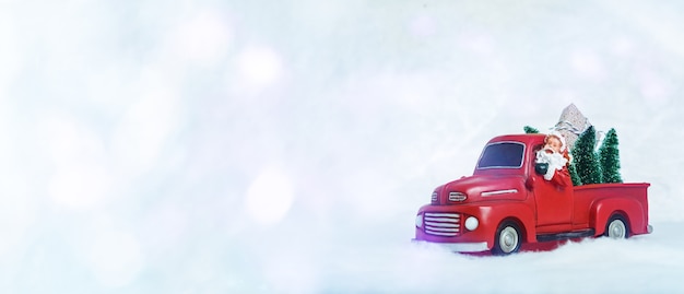 La decoración navideña de un coche rojo con Santa está en el fondo de luz con espacio de copia de bokeh