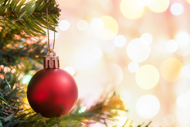 Decoración navideña. Colgando bolas rojas en ramas de pino guirnalda de árboles de Navidad y adornos sobre bokeh abstracto con espacio de copia