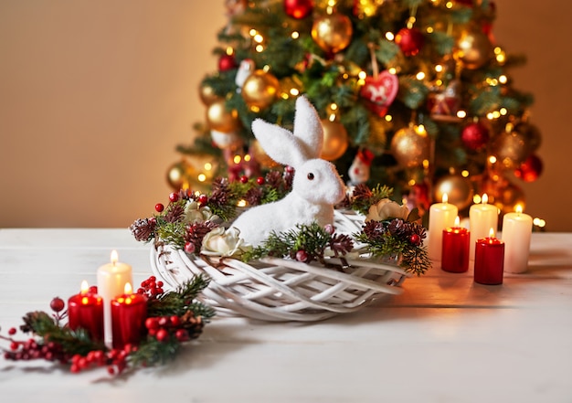 Decoración navideña conejo blanco con velas sobre una mesa