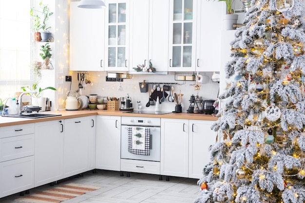 Decoración navideña festiva en cocina blanca interior rústico moderno con un árbol de Navidad nevado