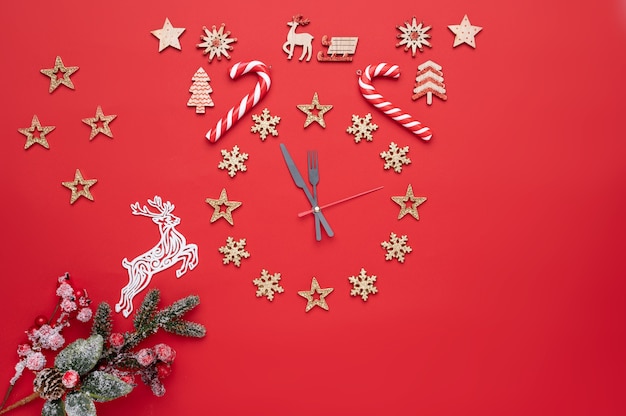 Decoración navideña en forma de reloj sobre un fondo rojo y también hay espacio libre para texto