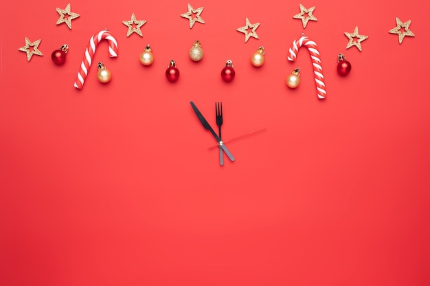 Decoración navideña en forma de reloj sobre un fondo rojo.