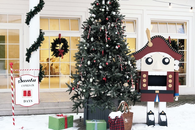 Decoración navideña en el patio trasero Árbol de Navidad con regalos un contador del número de días hasta Navidad y una gran figura de un cascanueces