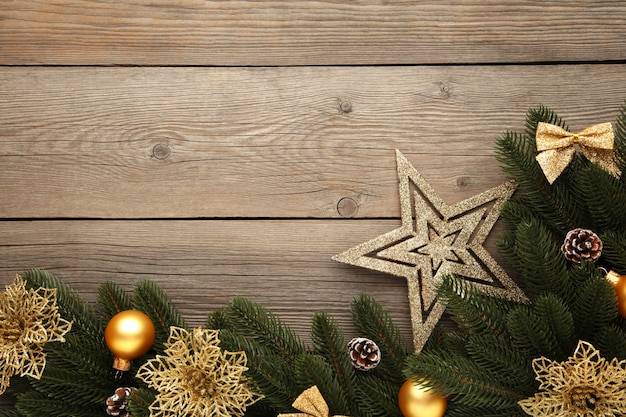 Decoración navideña. Rama de abeto con bolas de oro, flor de navidad y estrella en gris