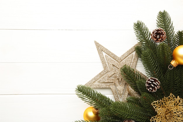 Decoración navideña. Rama de abeto con estrella de oro, flor de navidad y bolas en blanco