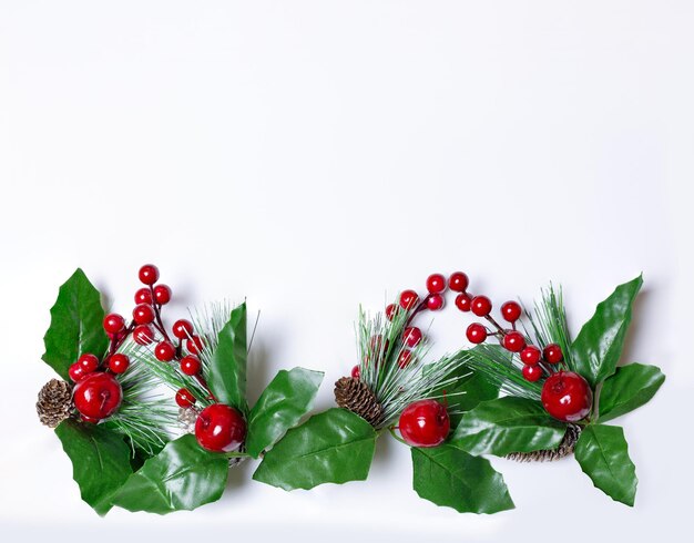 Decoración navideña con ramas de acebo Están en línea en la parte inferior de la imagen Fondo blanco