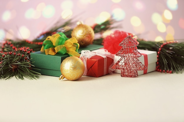 Decoración navideña y regalos en mesa blanca.
