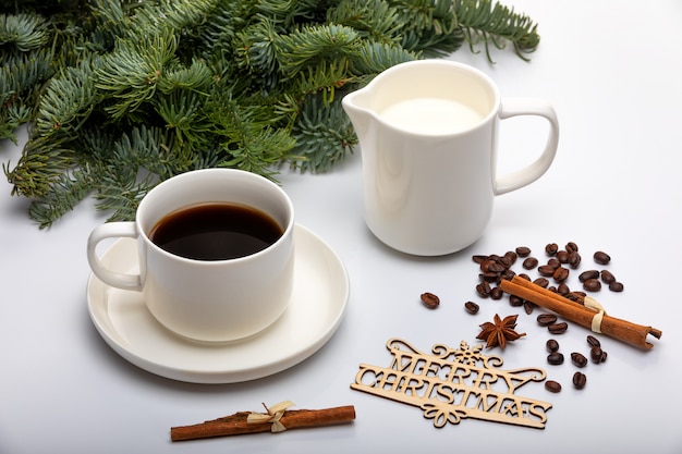 Decoración navideña. Taza de café exprés con leche, árboles de Navidad y texto de madera Feliz Navidad