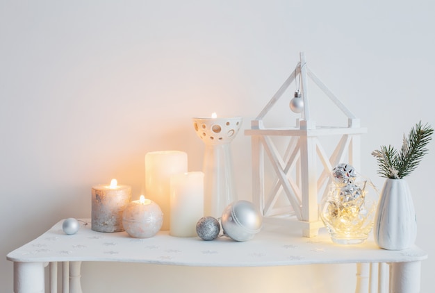 Decoración navideña con velas en la pared de fondo blanco