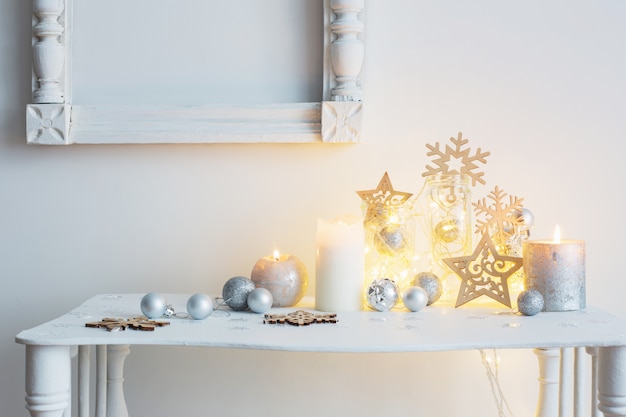 Decoración navideña con velas en la pared de fondo blanco