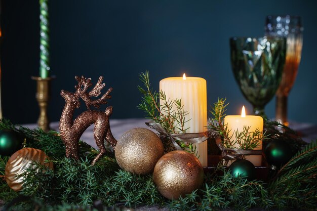 Decoración navideña verde y dorada en la mesa sobre fondo oscuro