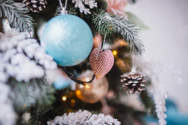 Decoración original y juguetes colgando en rico árbol de Navidad