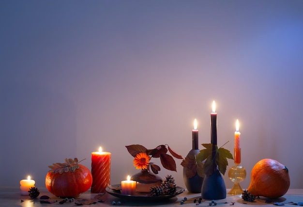 Decoración oscura de otoño con velas en un estante de madera en la pared de fondo