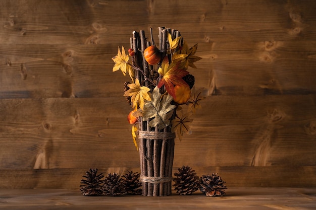 Foto decoración de otoño con decoración de madera, cono de pino y ramas sobre la mesa