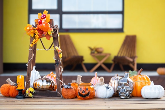 Foto decoración de otoño en el porche de la casa afuera en el patio de guirnaldas de linternas de calabaza, sombreros, linterna, fiesta de halloween, ambiente de otoño, festival de la cosecha