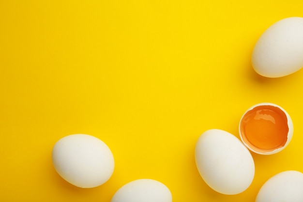Decoración de Pascua huevos blancos sobre fondo amarillo.