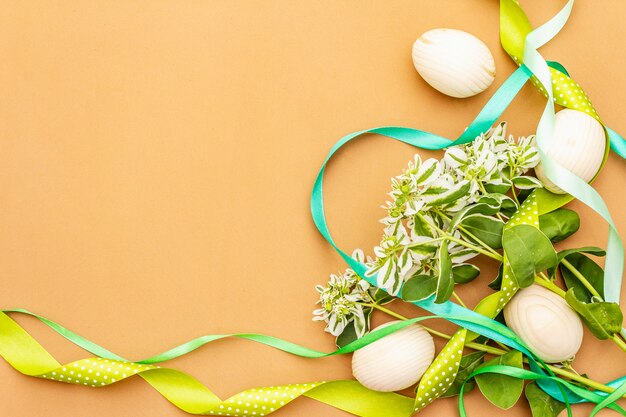 Decoración de pascua. Huevos, cintas, flores frescas y hojas.