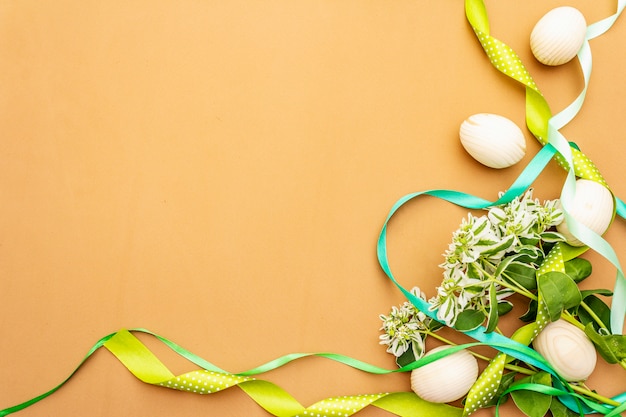 Decoración de pascua. Huevos, cintas, flores frescas y hojas.