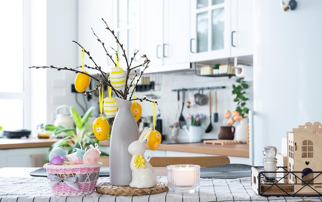 Decoración de Pascua de huevos coloridos en una canasta y un conejo en la mesa de la cocina en un estilo rústico Interior festivo de una casa de campo