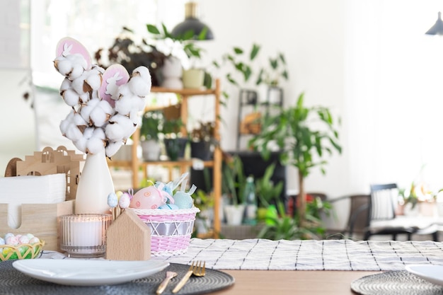 Decoración de Pascua de huevos coloridos en una canasta y un conejo en la mesa de la cocina en un estilo rústico Interior festivo de una casa de campo