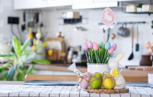 Decoración de Pascua de huevos coloridos en una canasta y un conejo en la mesa de la cocina en un estilo rústico Interior festivo de una casa de campo