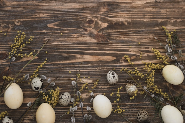 Decoración de Pascua con huevos de Pascua y flores de primavera. Huevos amarillos en madera