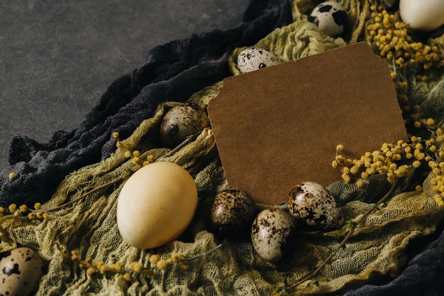 Decoración de Pascua con huevos de Pascua y flores de primavera. Huevos amarillos sobre gris