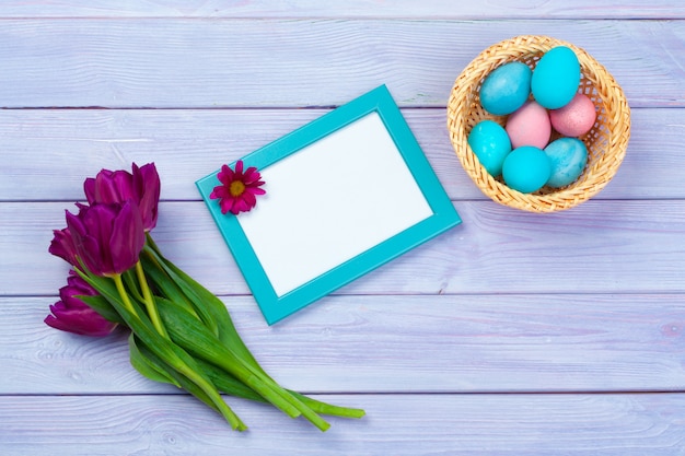 Decoración de Pascua con tulipanes, huevos y marco en blanco. Vista superior