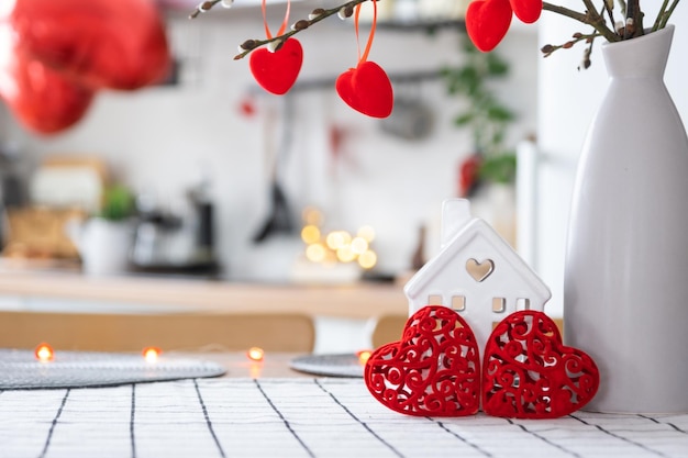 Decoración de San Valentín en la mesa de la cocina blanca en un hogar acogedor Espacio de copia Regalo para el nido de amor familiar del día de San Valentín Un jarrón con un ramo de corazones en un interior moderno