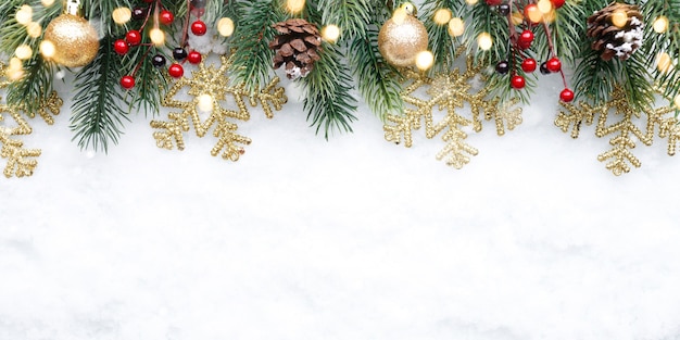 Decoración superior de Navidad con bolas de copos de nieve y conos sobre fondo de nieve