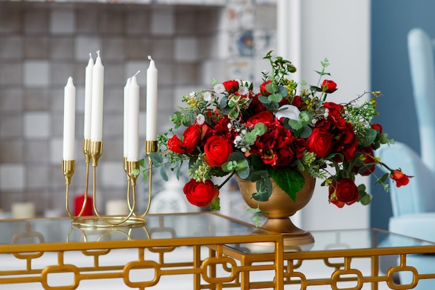 Decoración de velas en candelero y jarrón con flores.