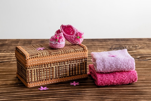 Decoración con zapato de bebé rosa, fondo de madera, espacio para texto