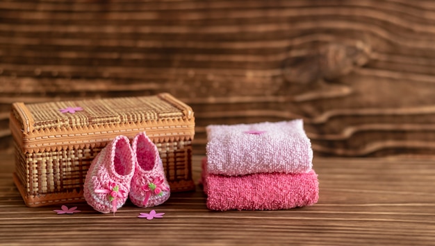 Decoración con zapato de bebé rosa, fondo de madera, espacio para texto