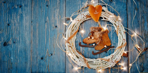 Decoraciones de año nuevo alrededor del espacio vacío de la carta de Navidad para guirnaldas de luces ardientes de texto sobre fondo de madera azul.