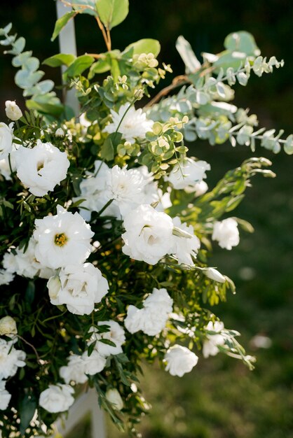 Decoraciones de boda elegantes hechas de flores naturales y elementos verdes.