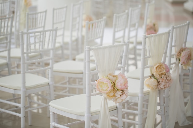 Decoraciones de la boda flores en sillas. Registro de salida de boda, sillas blancas decoradas para boda. Detalle de la configuración de la boda.