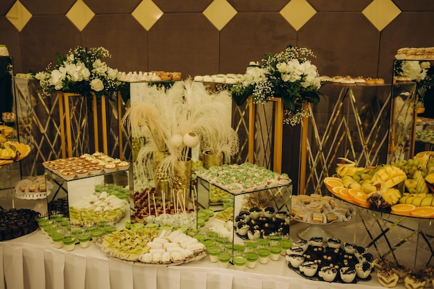 Decoraciones de boda Recepción Buffet Frutas y queso en platos con pan en cajas Barra de comida decorada con flores y farolillos