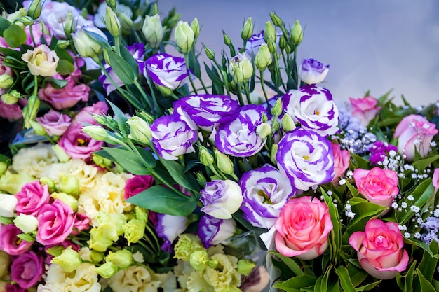 Decoraciones brillantes de flores sobre la mesa en una ceremonia de boda. Un grupo de coloridas flores rojas y violetas.