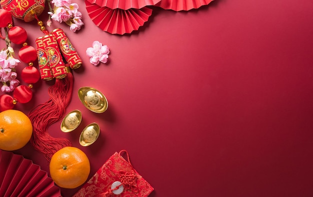 Decoraciones chinas de año nuevo hechas de paquetes rojos de naranja y lingotes de oro o bultos dorados Caracteres chinos FU en el objeto significa fortuna buena suerte riqueza y flujo de dinero