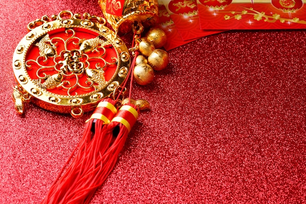 Decoraciones chinas del Año Nuevo y ornamentos propicios en fondo rojo del bokeh