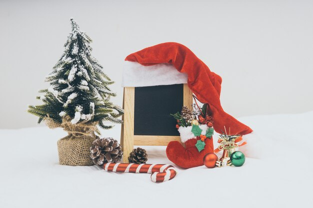 Decoraciones del día de fiesta de la Navidad con la pizarra en el fondo blanco.