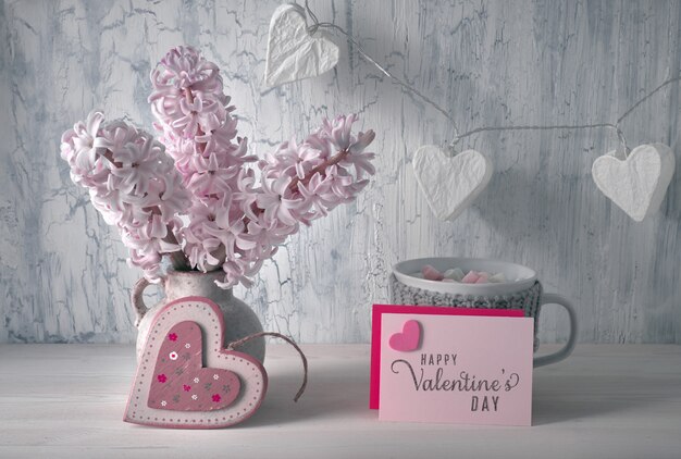 Decoraciones para el día de San Valentín, organizador de escritorio blanco con calendario de madera, taza de chocolate caliente y flores de jacinto rosa