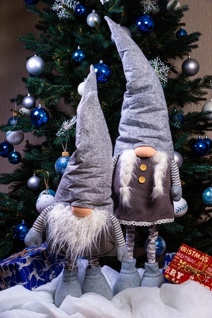 Decoraciones de duendes navideños Cuatro enanos con regalo de vacaciones de Navidad están sentados en un estante de madera Concepto de Navidad y Año Nuevo