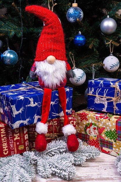 Foto decoraciones de duendes navideños cuatro enanos con regalo de vacaciones de navidad están sentados en un estante de madera concepto de navidad y año nuevo