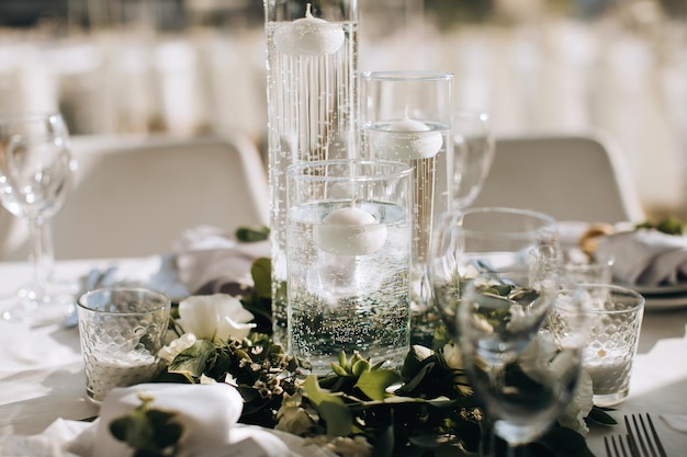 Decoraciones elegantes en la mesa de la boda con jarrones de velas y ramas de eucalipto