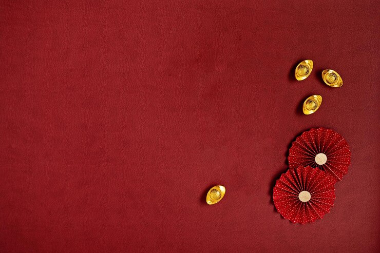 Decoraciones del festival de año nuevo chino hechas de abanicos de papel rojo chino y lingotes de oroCopyspace