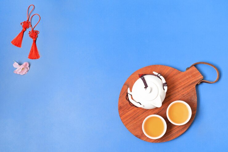Decoraciones del festival de año nuevo chino con juego de té en bandeja de madera y flores Mockup copyspace