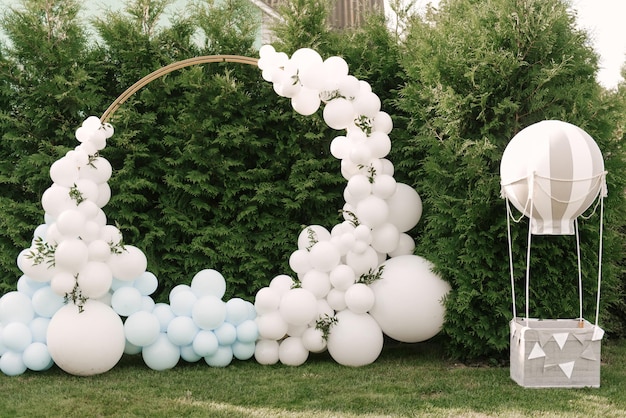 Decoraciones para fiestas navideñas Muchos globos colores azul y blanco Zona de fotos redonda con pelotas al lado de una pelota con una canasta para un niño