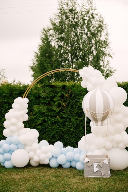 Decoraciones para fiestas navideñas Muchos globos colores azul y blanco Zona de fotos redonda con pelotas al lado de una pelota con una canasta para un niño